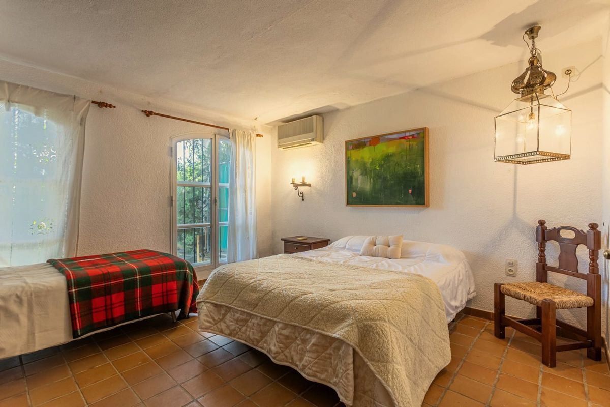 Dormitorio doble con cuadro y lámpara de forja